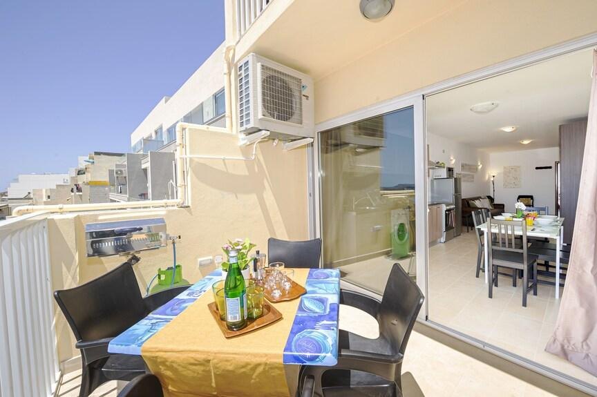 Terrasse équipée d'une climatisation, avec salle à manger visible en arrière-plan