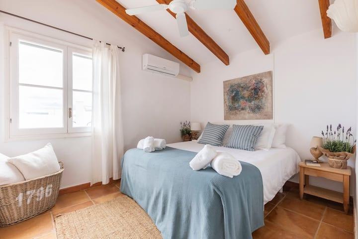 Chambre avec literie soignée, serviettes pliées et lumière naturelle
