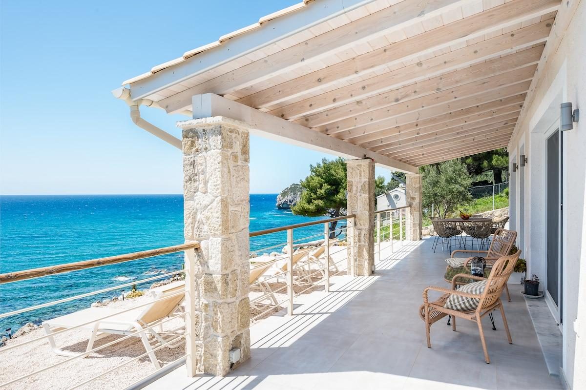 Terrasse en pierre avec vue mer et coin repas extérieur